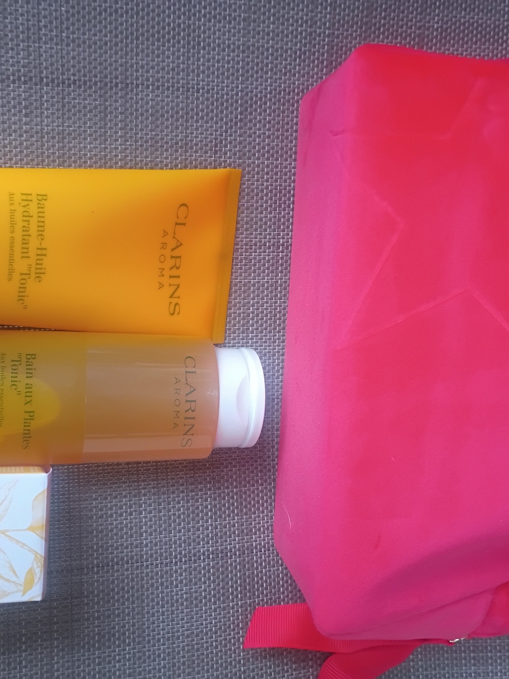 Clarins yellow body care set with pink travel pouch